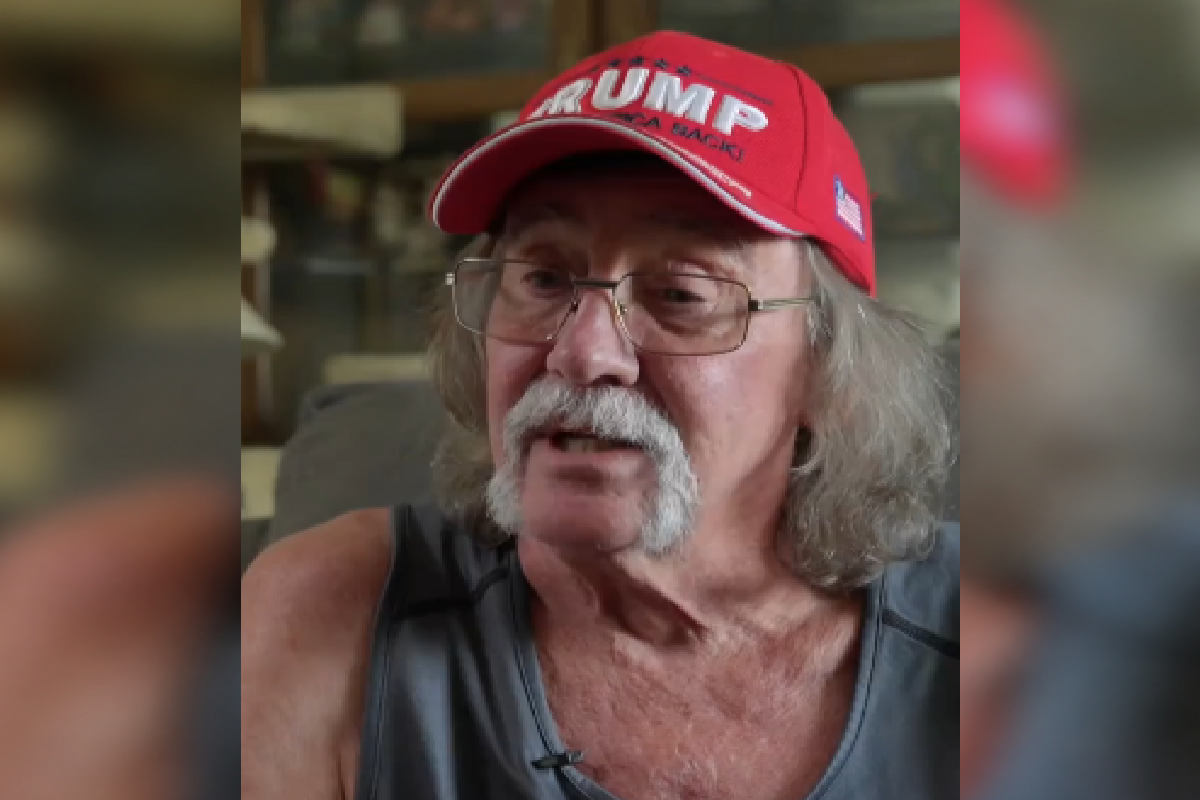 Older man with glasses wearing red Trump hat
